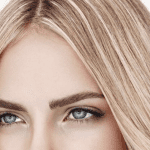 Close-up of a woman's perfectly shaped eyebrows achieved through microblading and threading.